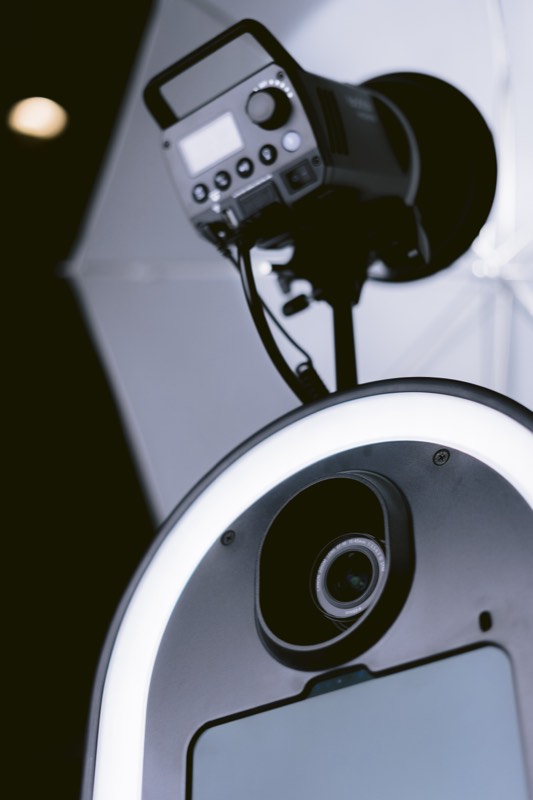 Close-up of the booth's ring light, camera lens and studio flash head